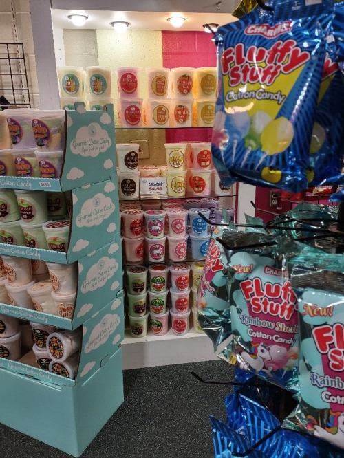 A colorful display of various cotton candy products and flavors in a retail setting.