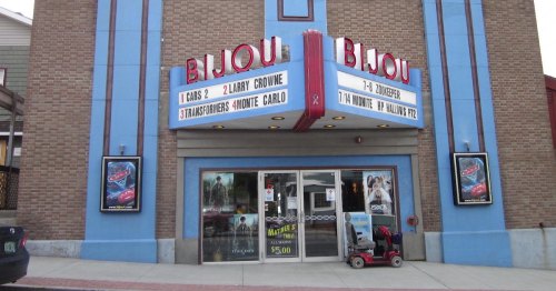 Exterior of the Bijou theater featuring movie posters and a marquee listing current films.