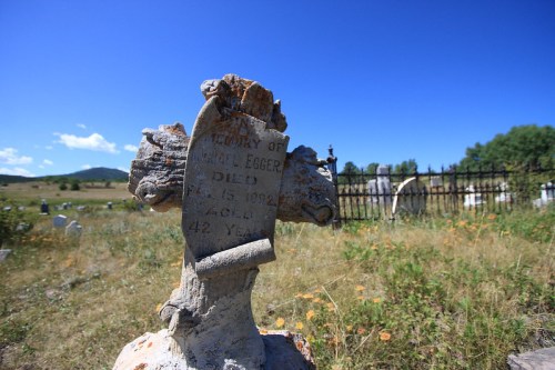 A weathered gravestone in a grassy cemetery, marking the resting place of Jules Egger, who died in 1924 at age 42.