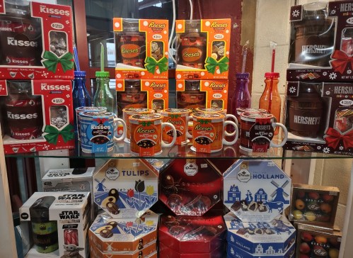 A display of various candy and chocolate products, including mugs, gift boxes, and themed items.