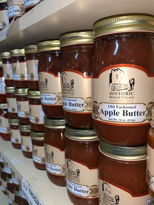 Jars of apple butter lined up on a shelf, labeled "Old Fashioned" from Historic Roscoe Village.