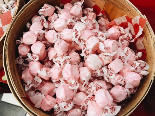 A wooden basket filled with pink wrapped candies, creating a colorful and inviting display.