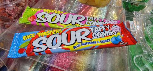 Two colorful candy packages labeled "Face Twisters Sour Taffy Combo" in strawberry and blue raspberry & cherry flavors.