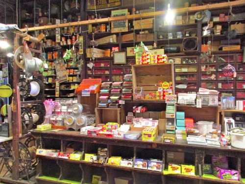 A vintage store display filled with various products, including boxes, cans, and jars, set against a wooden backdrop.