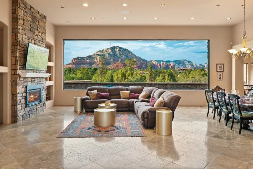Spacious living room with a large window showcasing a mountain view, featuring a cozy sofa and elegant decor.