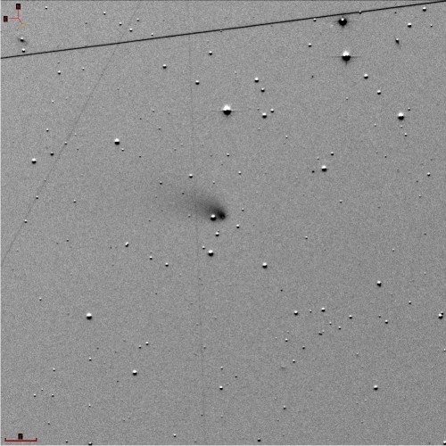 A grayscale image of a starry sky with numerous small dots, featuring a faint, blurred object in the center.