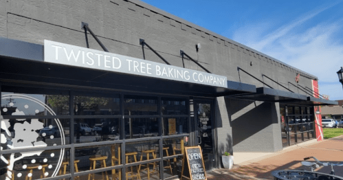 Exterior of Twisted Tree Baking Company with a sign and large windows, showcasing a welcoming atmosphere.