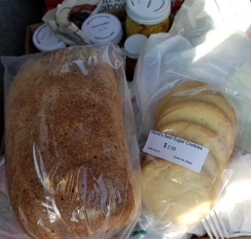 A loaf of bread and a package of sugar cookies labeled "World's Best Sugar Cookies" priced at $2.50.