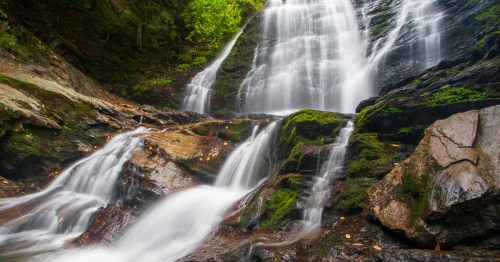 Moss Glen Falls in Vermont, flowing rapidly on a verdant spring day.