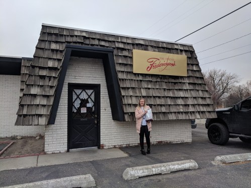 A woman stands outside a restaurant with a distinctive shingled roof and a sign that reads "Frederick's."