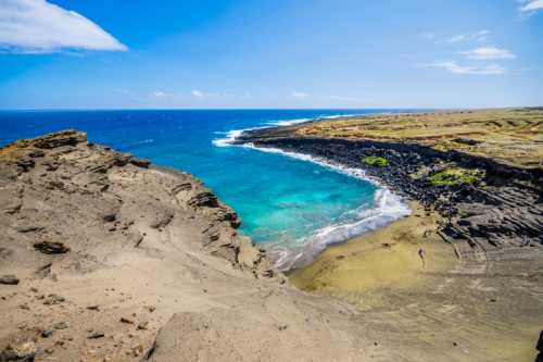 A scenic coastal view featuring turquoise waters, rocky cliffs, and a sandy beach under a clear blue sky.