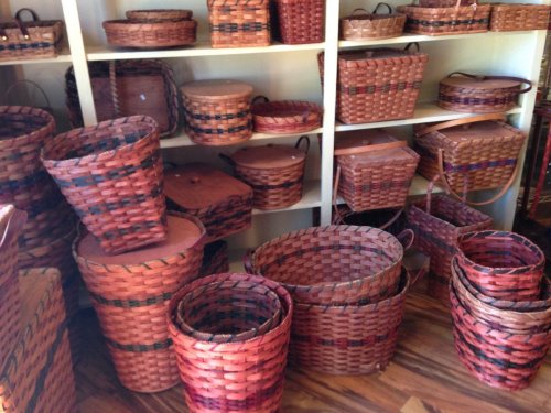 A variety of woven baskets in different shapes and sizes displayed on shelves and the floor.