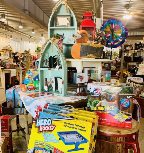 A colorful display of toys and games, including a hockey set, on shelves in a charming store.