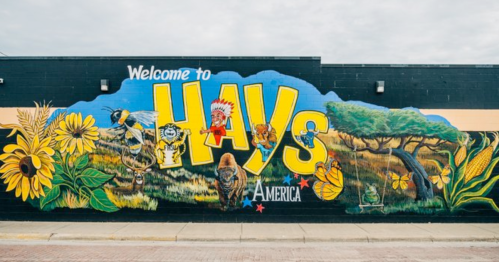Colorful mural reading "Welcome to Hays, America," featuring sunflowers, wildlife, and local symbols.