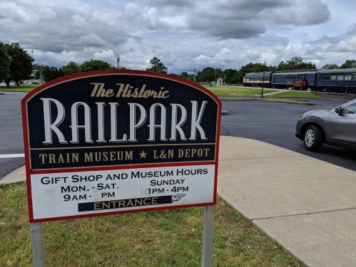 Sign for The Historic Railpark Train Museum and L&N Depot, listing hours and entrance details.