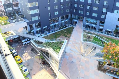 Aerial view of a modern building complex with a landscaped courtyard featuring a star-shaped design and greenery.
