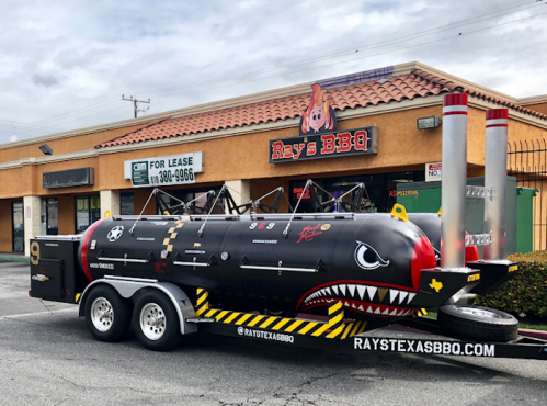 A unique BBQ trailer with a shark design parked outside Ray's BBQ restaurant.