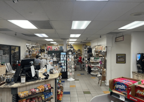 A view of a store interior with shelves of merchandise, a checkout counter, and customers browsing.