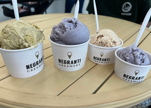 Four cups of ice cream in varying flavors sit on a round table, each labeled with "Negranti Creamery."