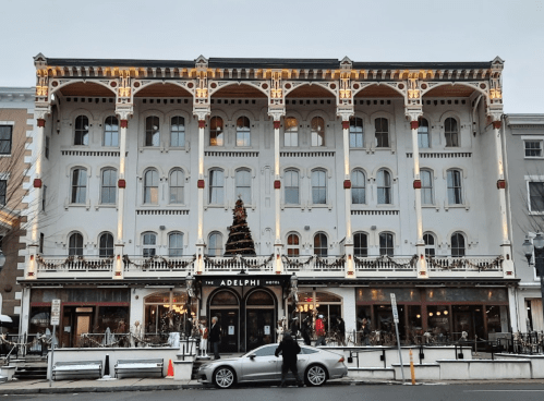 Historic Adelphi Hotel with festive decorations and a car parked in front, set against a wintery backdrop.
