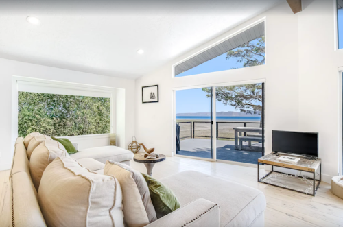 Bright, modern living room with large windows showcasing a scenic view of the outdoors and a cozy sofa.