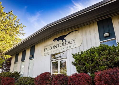 Exterior of the Museum of Paleontology at Brigham Young University, featuring a dinosaur silhouette on the sign.