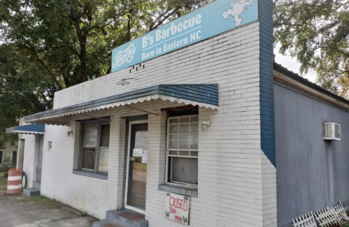 A small, closed barbecue restaurant with a blue and white sign reading "B's Barbecue" in Eastern NC.