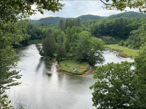 A serene river scene with a small island, surrounded by lush greenery and tents, under a cloudy sky.