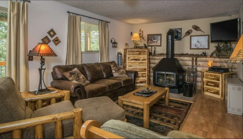 Cozy living room with brown sofas, wooden furniture, a fireplace, and decorative accents in a warm, inviting atmosphere.