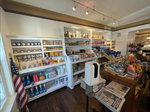 A well-stocked pantry with shelves of various food items, a wooden counter, and an American flag in the corner.