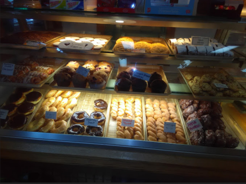 A display case filled with various baked goods, including pastries, cookies, and muffins, all neatly arranged.
