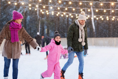 A family ice skating together outdoors, surrounded by snow and festive lights, enjoying a winter day.