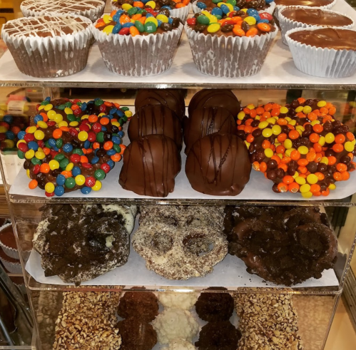 A display of assorted chocolate treats, including cupcakes, chocolate-covered snacks, and colorful candy-coated desserts.