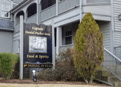 Sign for Captain Daniel Packer Inn, featuring a ship image, with "Food & Spirits" and "Parking in Rear" text.