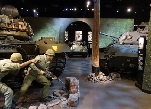 A museum exhibit featuring military tanks and a soldier figure in a historical setting.