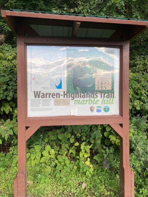 Sign for Warren-Highlands Trail in Marble Hill, featuring a map and information about the trail and surrounding area.