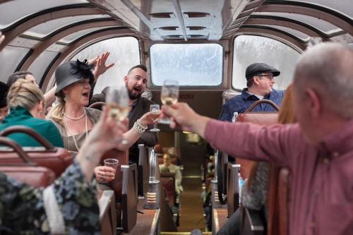 A lively group of people celebrating inside a train car, raising glasses and enjoying the moment.