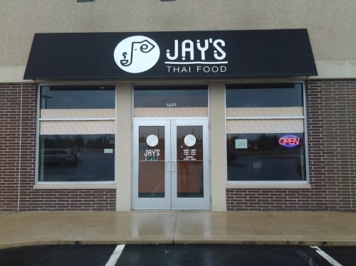 Exterior of Jay's Thai Food restaurant, featuring a sign and large windows with an "OPEN" neon light.