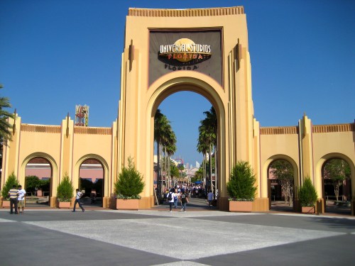 Entrance to Universal Studios Florida, featuring a large archway and palm trees under a clear blue sky.