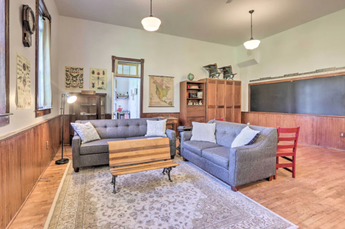 Cozy living room with two gray sofas, a wooden coffee table, and a vintage map on the wall. Warm, inviting atmosphere.