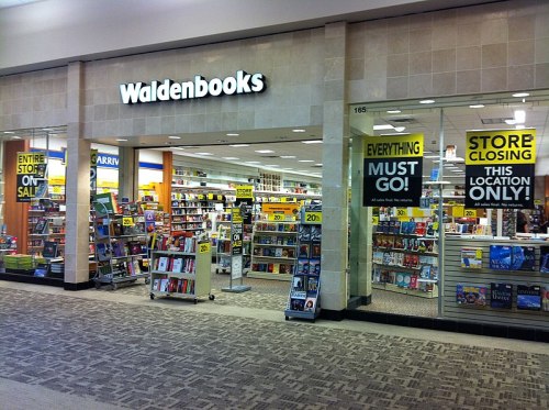 A Waldenbooks store with signs announcing a closing sale and discounts, featuring shelves filled with books.