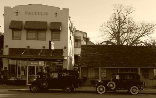 Historic bakery building with vintage cars parked outside, captured in a sepia tone.