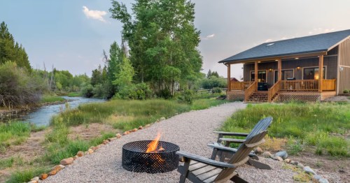 A waterfront cabin in Wyoming with a fire pit and outdoor seating.