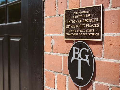 Plaque on a brick wall indicating the property is listed in the National Register of Historic Places.