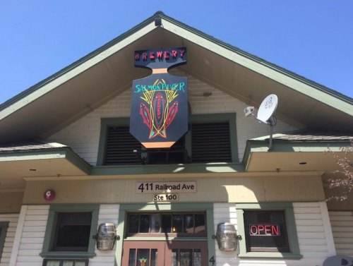 Exterior of a brewery with a colorful sign, "Shamrocker," and an "Open" neon sign, located at 411 Railroad Ave, Ste 100.