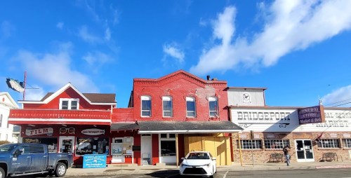 Historic buildings in a small town, featuring colorful facades and a clear blue sky above.