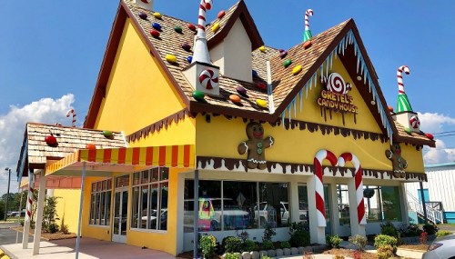 A colorful candy-themed building with a sloped roof, decorated with candy canes and gumdrops.