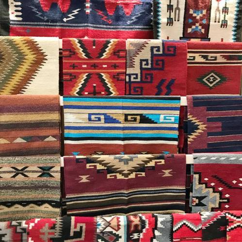 A collection of colorful woven rugs featuring intricate geometric patterns and designs.