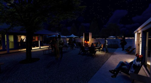 A nighttime scene of people socializing outdoors, with a fire pit, seating areas, and illuminated buildings in the background.