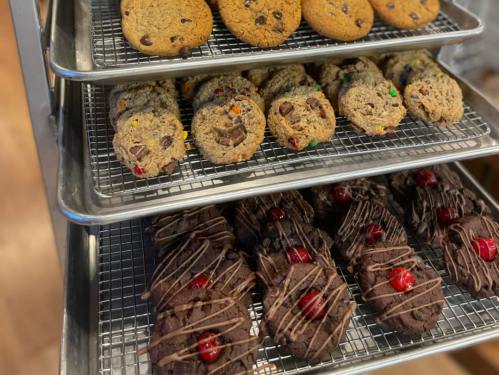 A tray of assorted cookies, including chocolate chip, oatmeal, and chocolate cookies with cherries and drizzled chocolate.